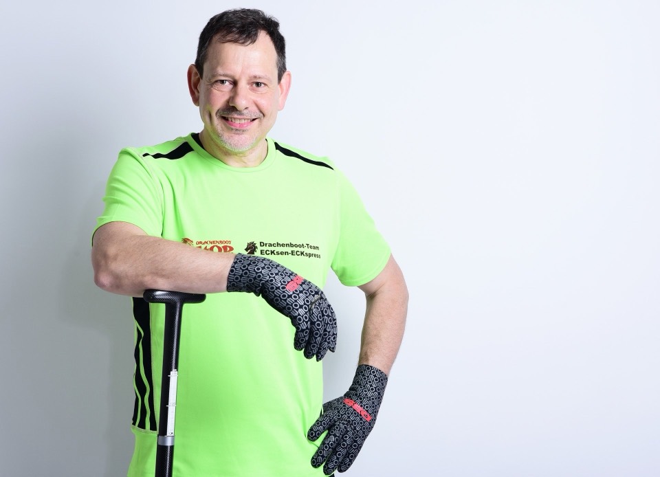Stehend im Drachenboot-Shirt und mit Paddel